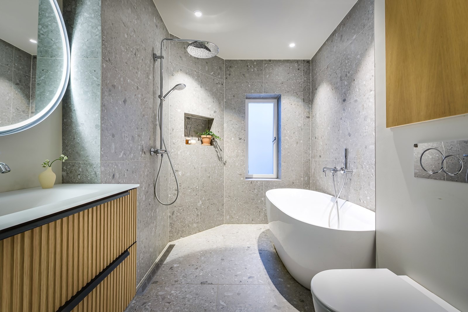 Lekkert, påkostet bad med innebygde skap, flislagte overflater og behagelig gulvvarme Galleribilde