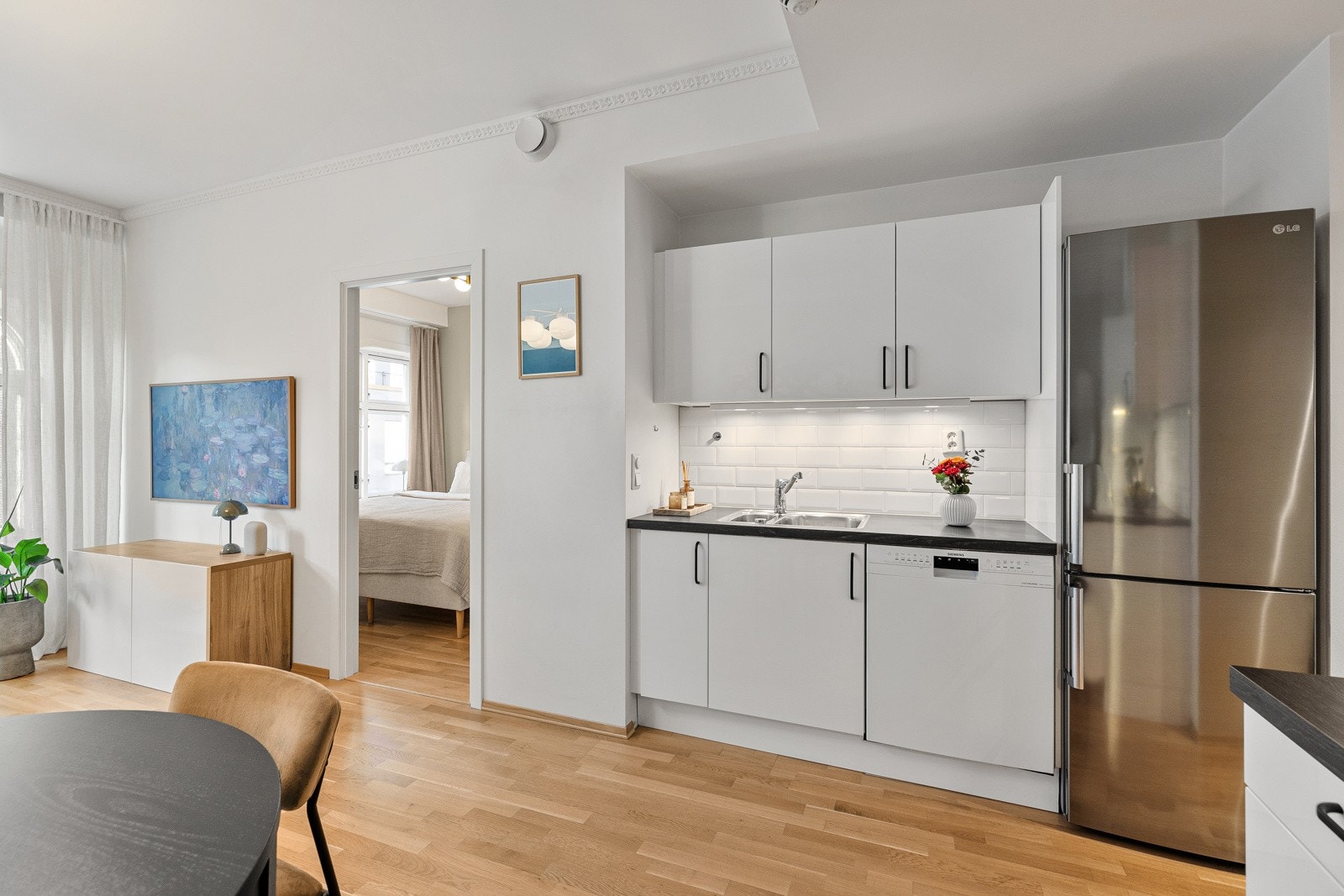 Kjøkkenet er utstyrt med integrerte hvitevarer, inkludert komfyr og oppvaskmaskin, samt fritstående kjøle- og fryseskap Galleribilde