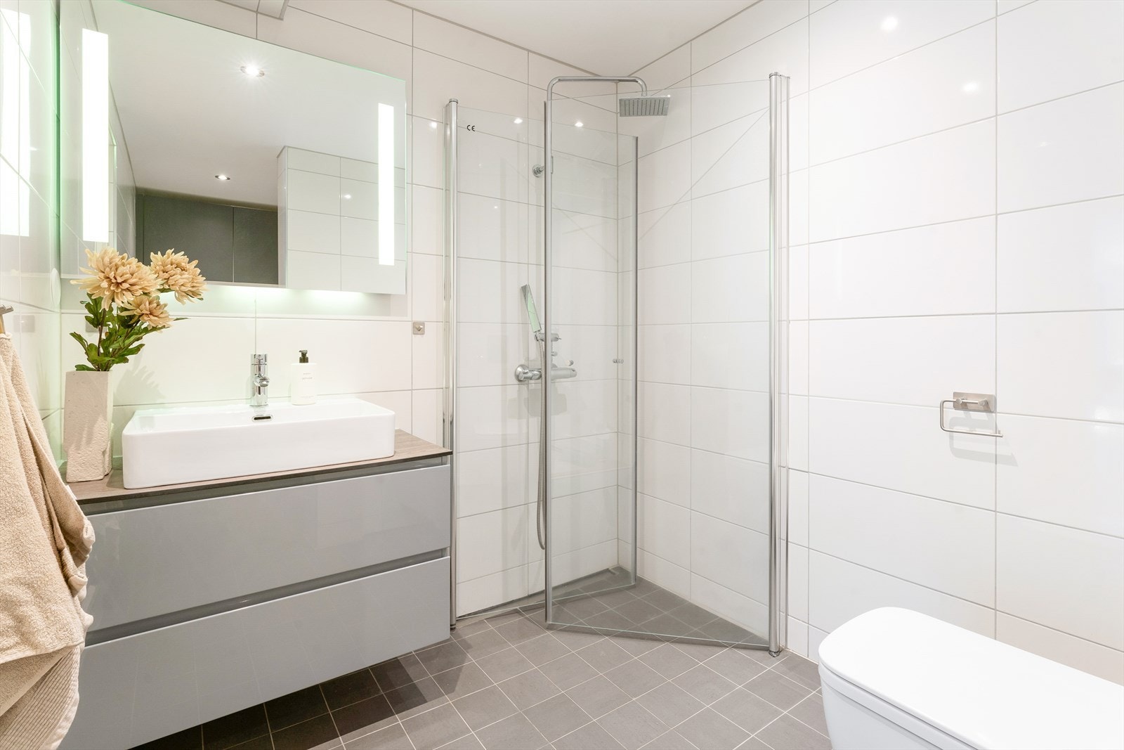 Flislagt baderom med vannbåren gulvvarme og malt himling med integrert belysning. Galleribilde