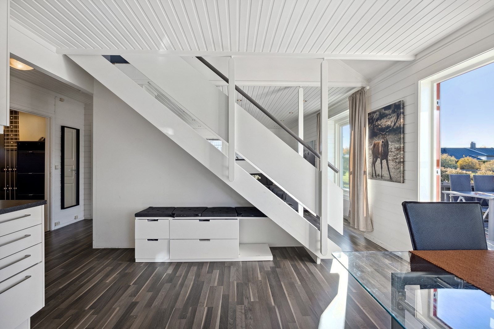 Et mørkt laminatgulv bidrar til en flytende overgang mellom stuen og kjøkkenet. Galleribilde