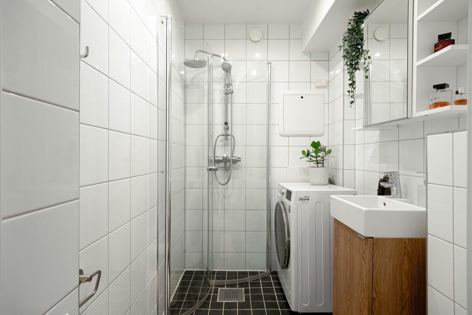 Badet er innredet med vegghengt toalett, dusjhjørne, servant med skapinnredning og speilskap. Det er varme i gulvet og downlights i himling. Galleribilde