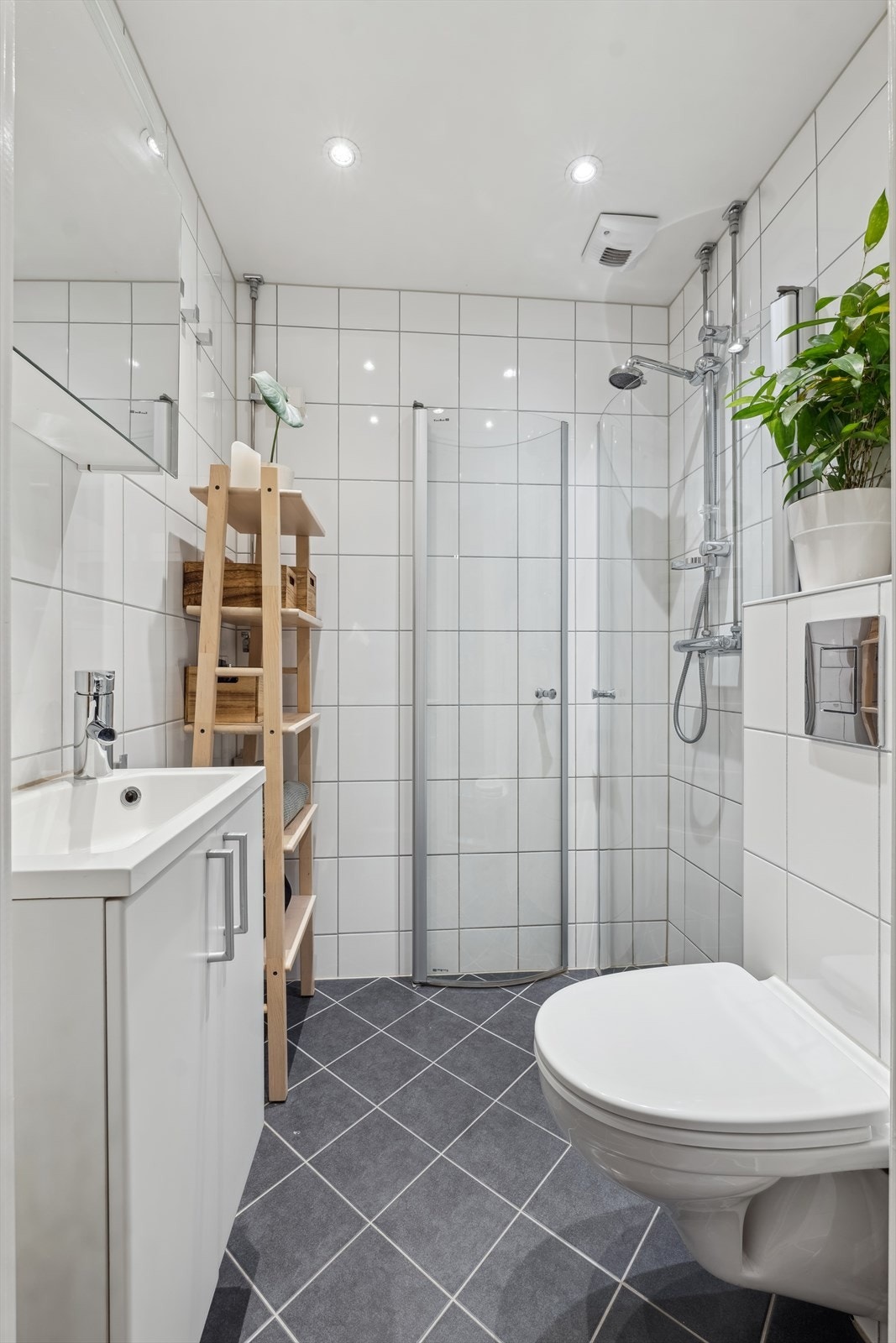 Delikat og flislagt baderom fra 2015. Baderommet er utstyrt med toalett, dusjhjørne, servant med underskap. Galleribilde