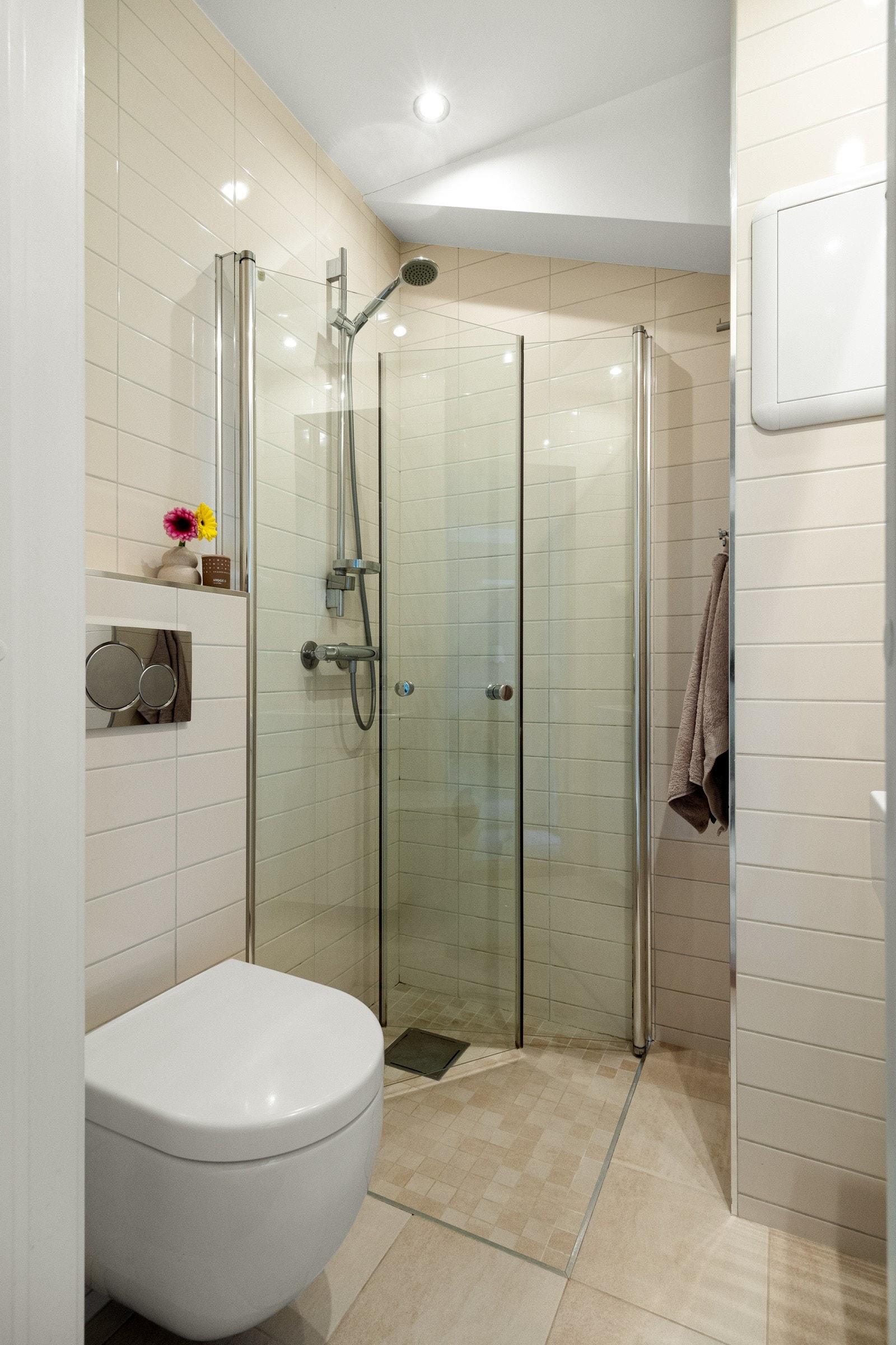 Her er det varmekabler i gulvet og downlights i himling. Det er også eget dusjhjørne, vegghengt toalett, servant med skap og speilskap. Galleribilde