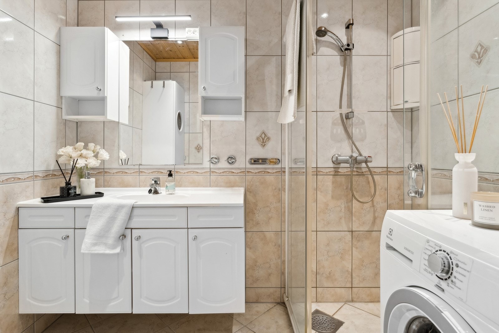 Badet har flis på gulv og vegg og panel i himlingen. Badet måler 3,6 kvm og har plass til vaskemaskin. Galleribilde