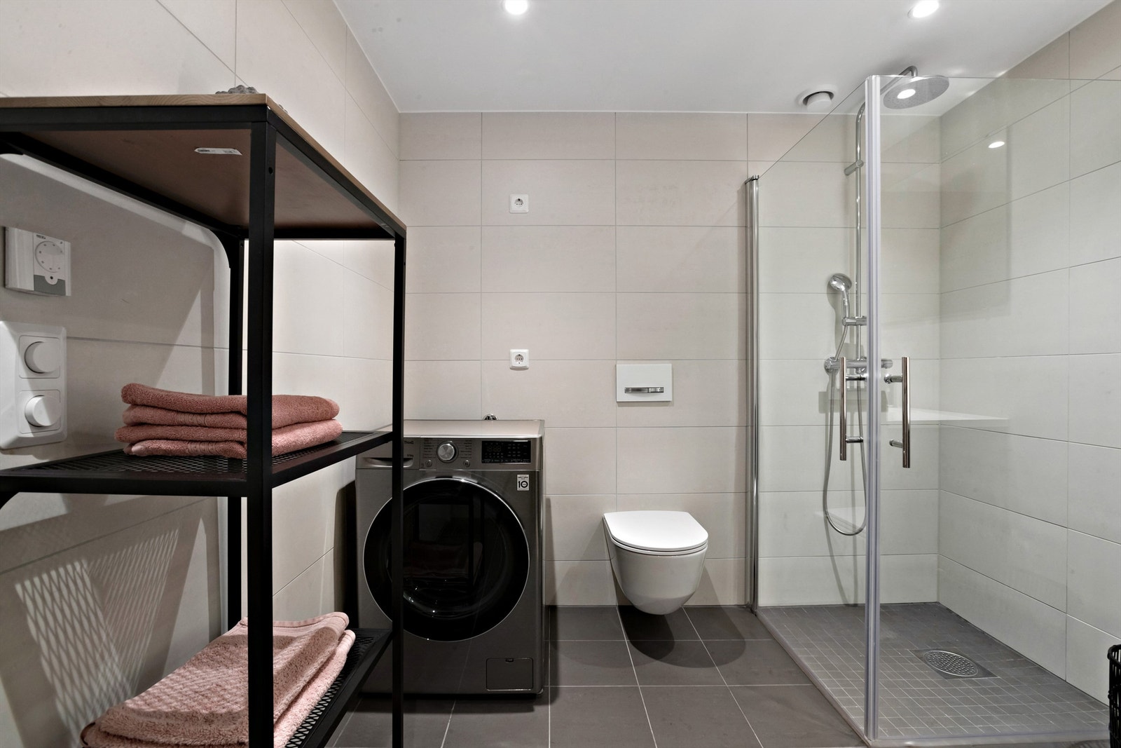 Badet har veggmontert klosett med innbygget sisterne, servantskap, dusjnisje og opplegg for vaskemaskin, samt tørketrommel Galleribilde