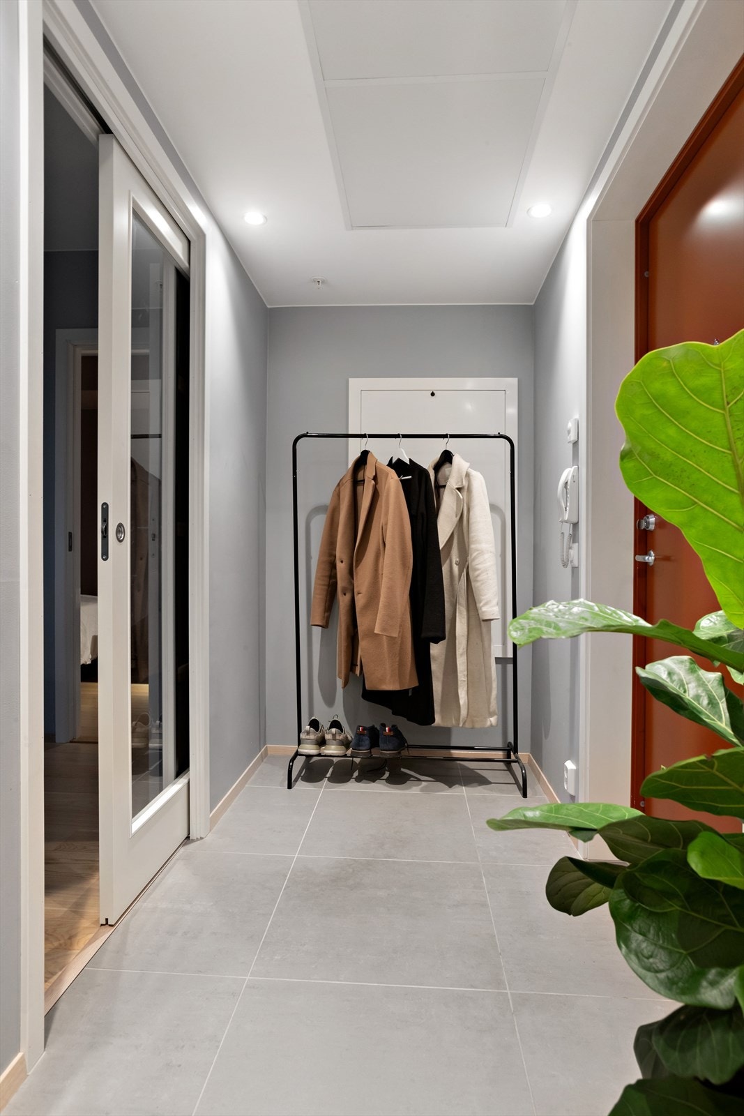 Velkommen inn i en lys og flislagt entré Galleribilde