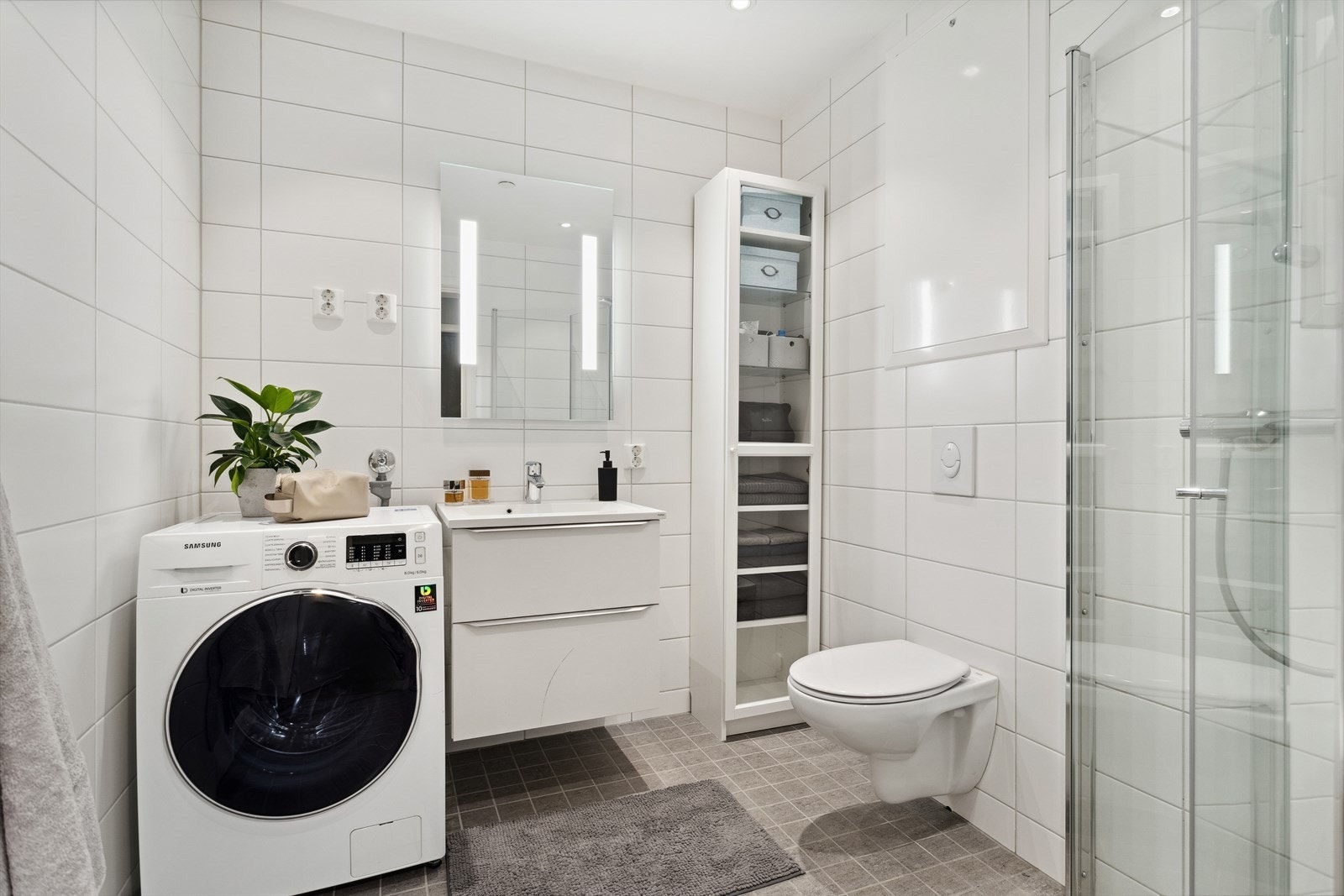 Badet har innfellbare dusjdører, vegghengt toalett, gulvvarme og opplegg for vaskemaskin Galleribilde