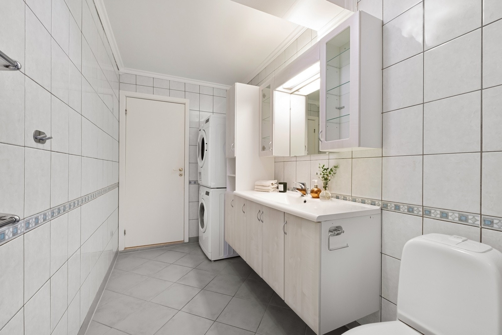 Videre er badet utstyrt med dusjkabinett, servant med innredning og toalett. Galleribilde