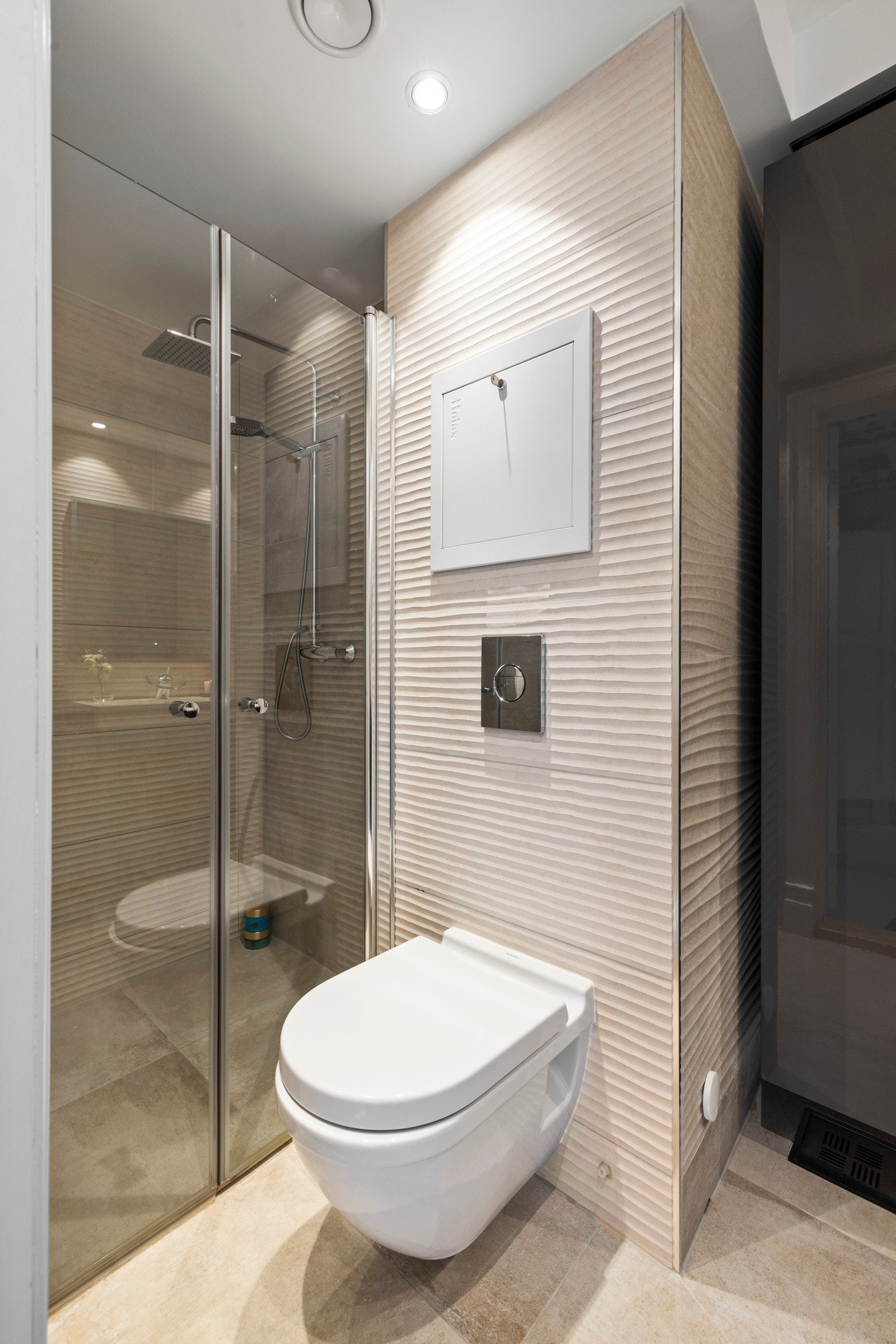 Badet har vegghengt toalett, opplegg for vaskemaskin og dusjnisje Galleribilde