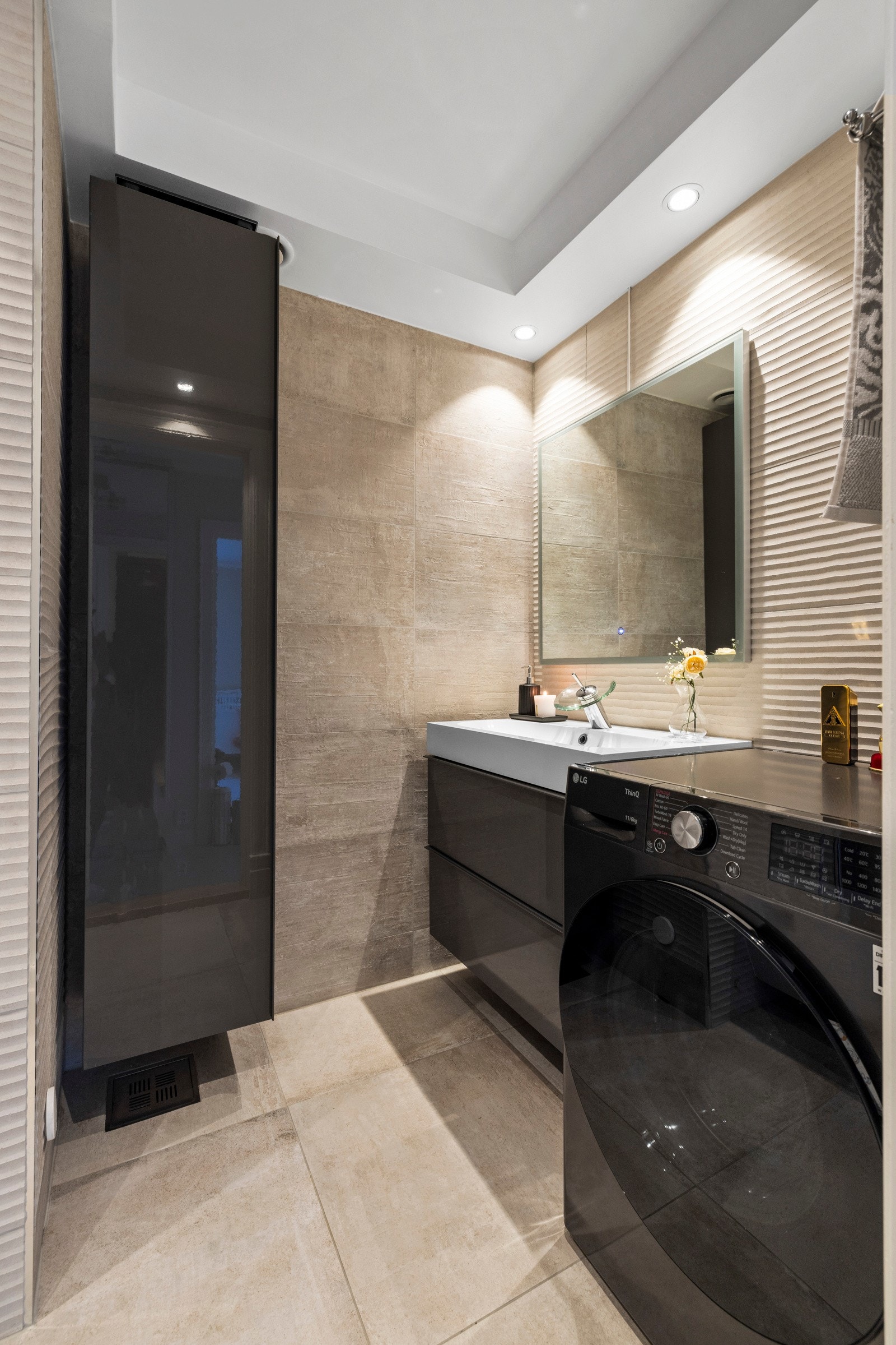 Rommet har stilige, beige fliser med ulike overflater som skaper et spennende uttrykk Galleribilde