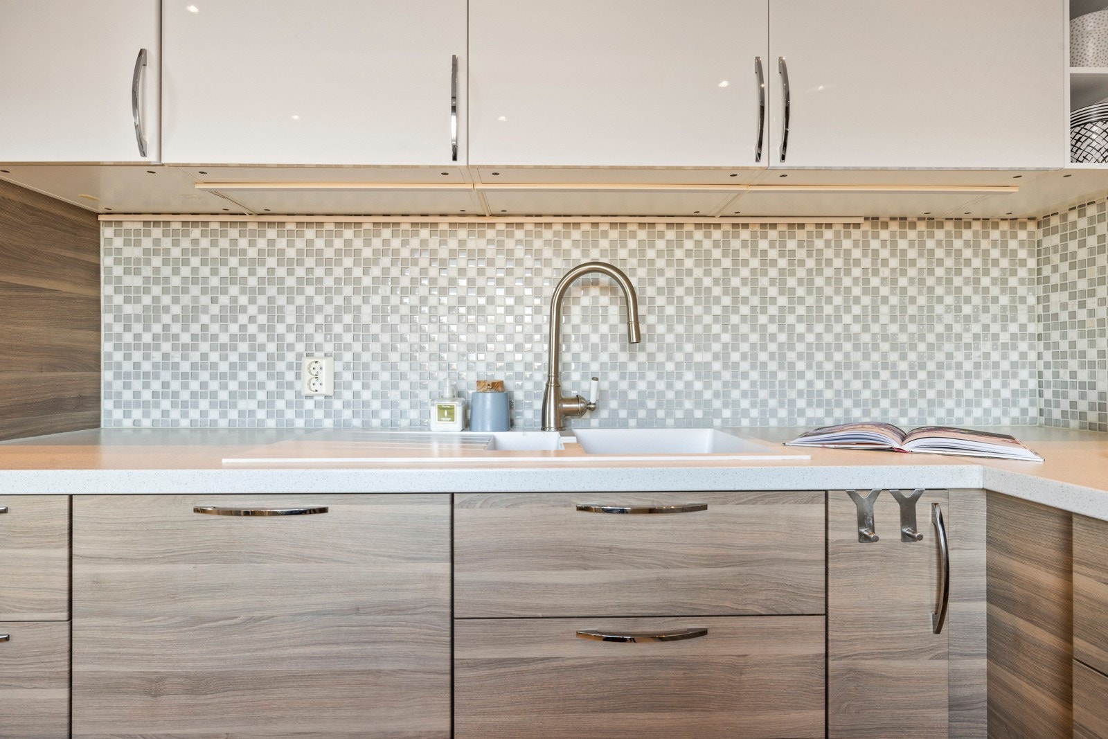 Veggene er gråmalt og har matchende mosaikkfliser over hele kjøkkenbenken Galleribilde