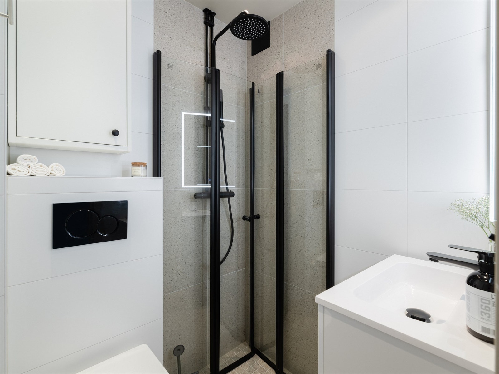 Sort dusjarmatur og to-leddede dusjdører, montert våren 2024. Galleribilde