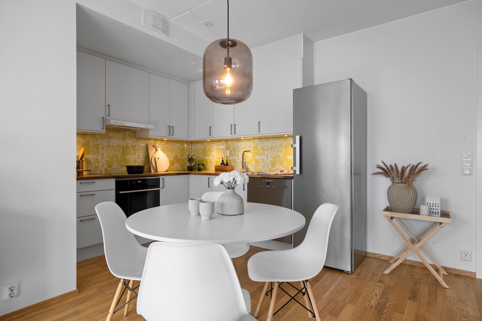 Mellom stue og kjøkken er det naturlig plass til et stort, sosialt spisebord. Med kort vei fra kjøkkenet er det enkelt å servere alle dagens måltider! Galleribilde