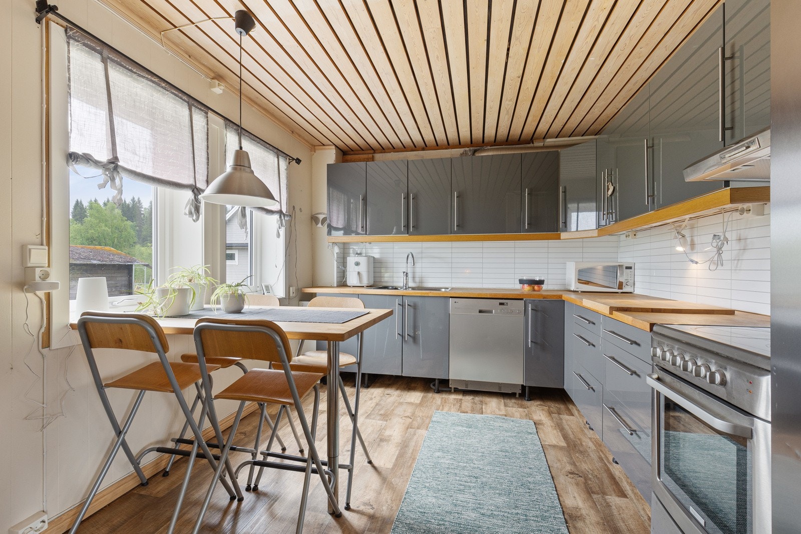 Kjøkken med mye skap- og benkeplass - Praktisk spiseplass ved vinduet på kjøkkenet Galleribilde