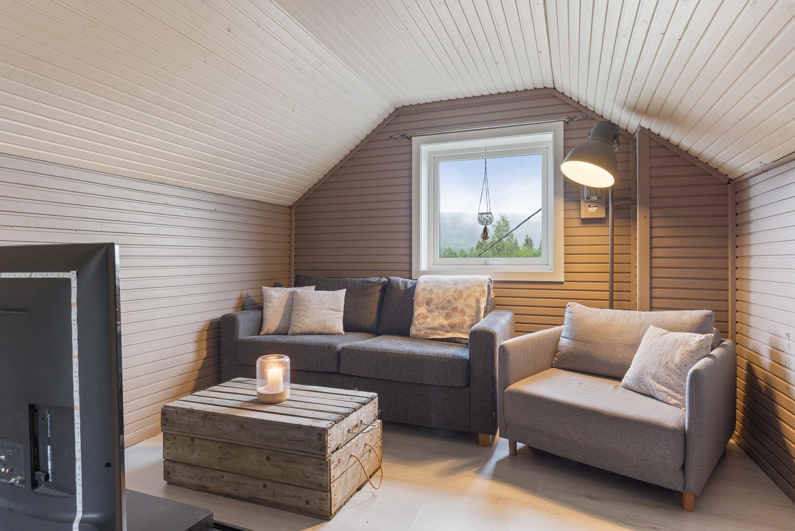 En loftstue med plass til hyggelig sofagruppe med tilhørende møblement Galleribilde