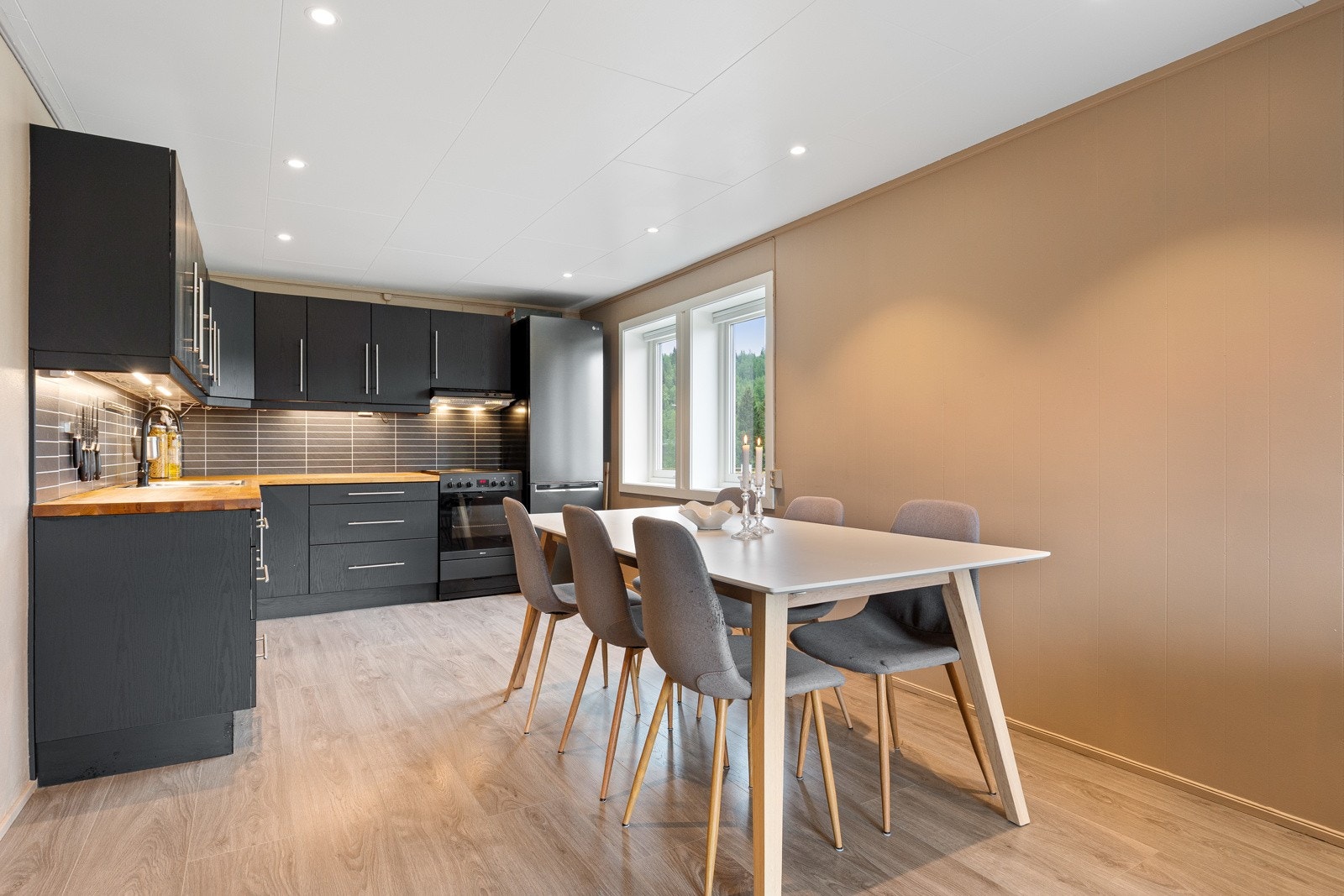 Et flott tidløst kjøkken og en åpen løsning mot stue som gir boligen en sosial planløsning Galleribilde