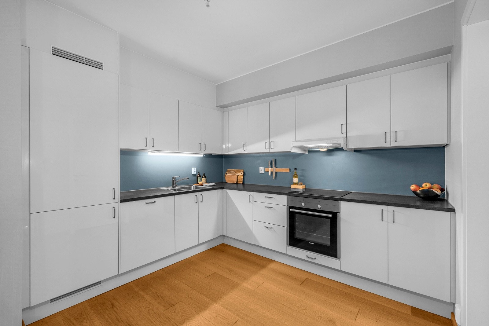 Kjøkkenet ligger i åpning mot stuen, som gjør rommet mer sosialt ved besøk. Leiligheten er utstyrt med kjøkkeninnredning fra Norema og er fra byggeår 2018. Galleribilde