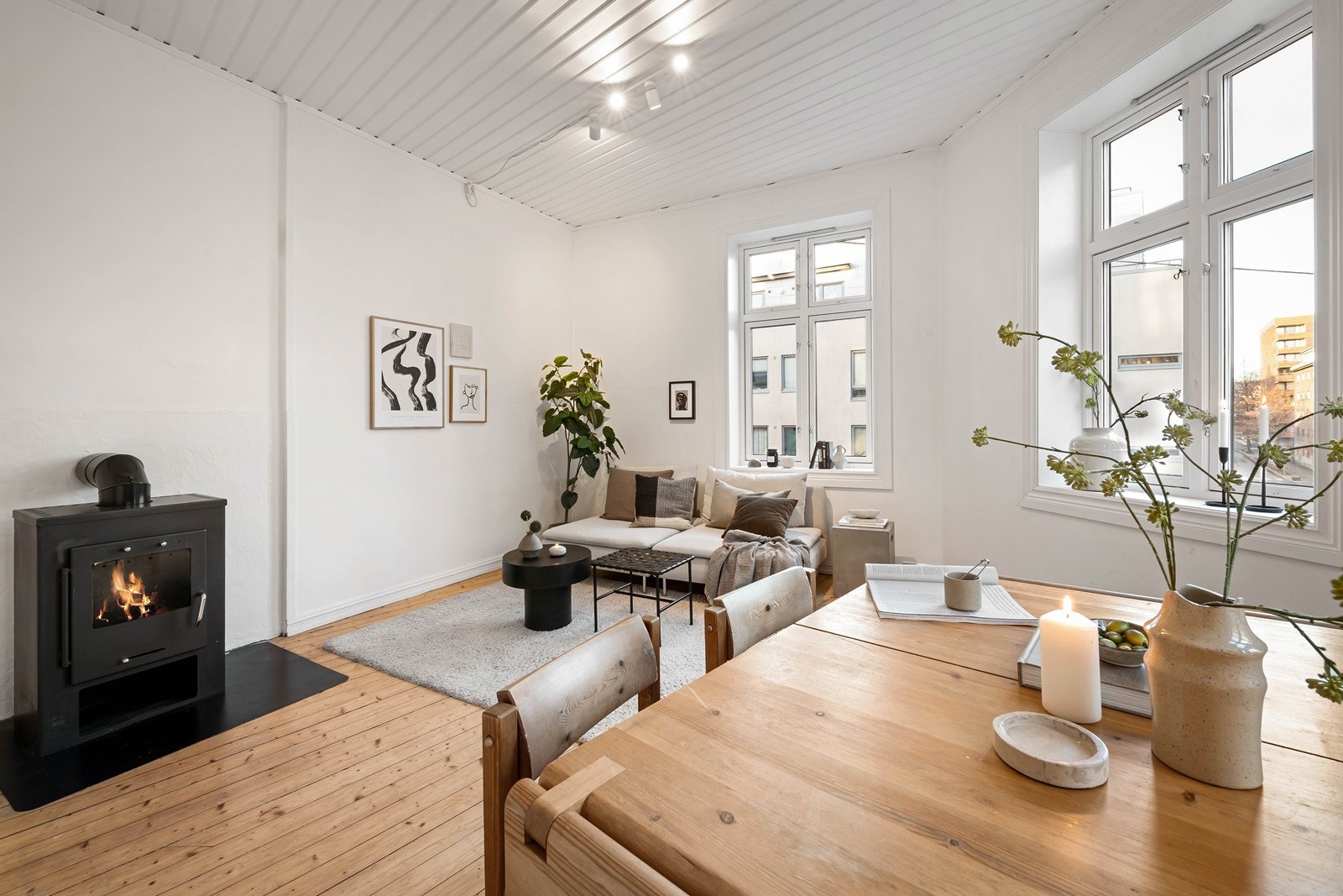 Tre store vinduer i hjørnet gir mye lys og luftig atmosfære Galleribilde