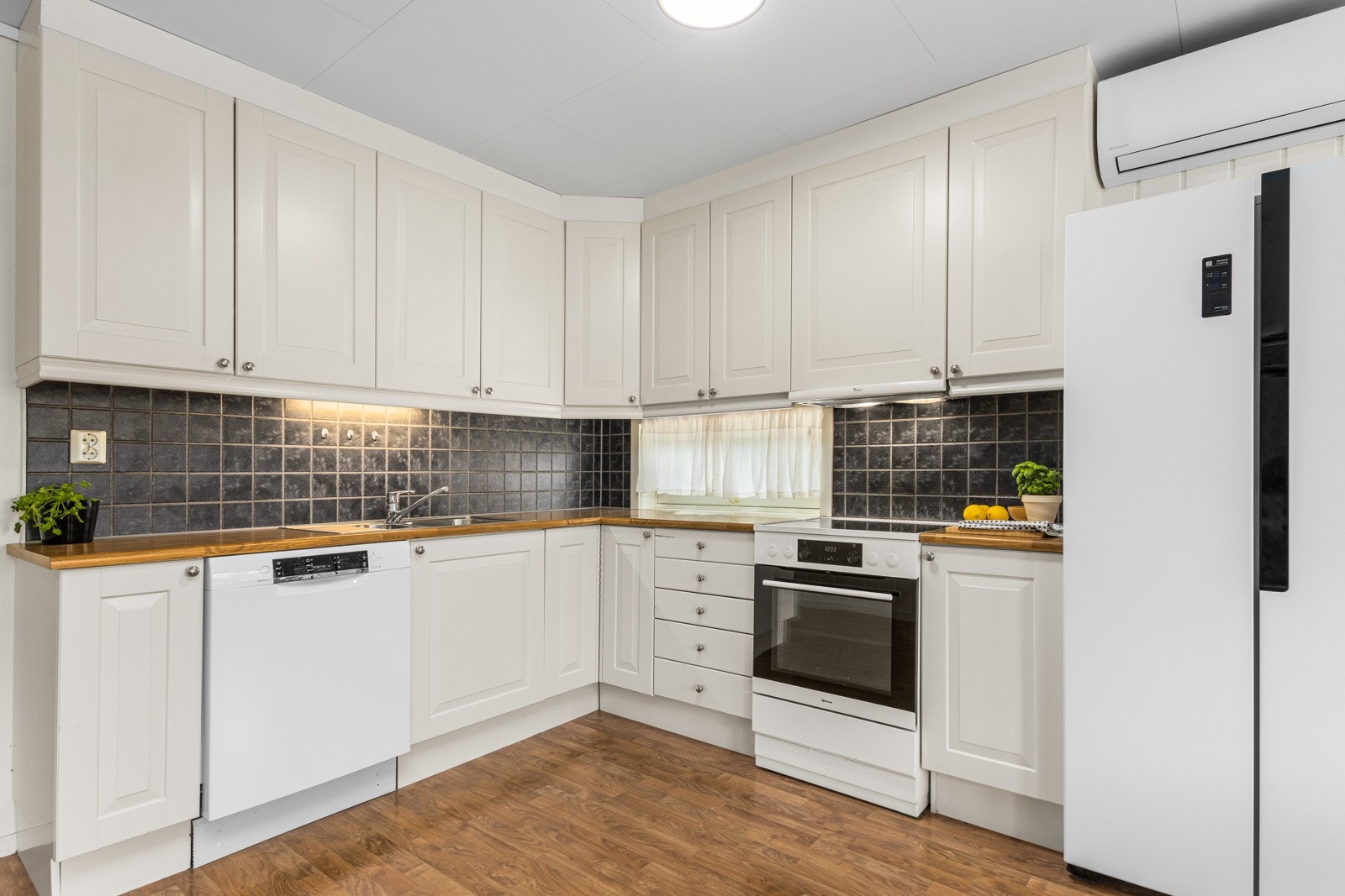 Flott kjøkken med himlingshøye overskap for maksimal plassutnyttelse. Galleribilde