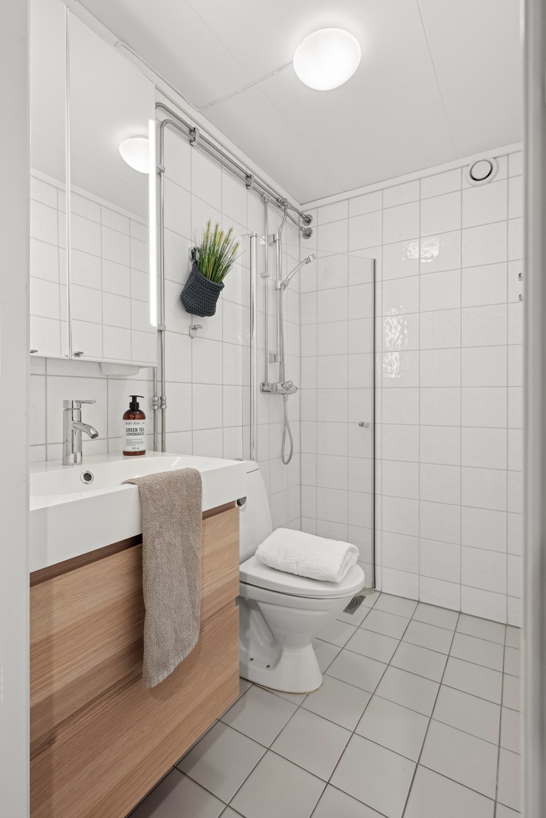 Leiligheten har et baderom med flislagte overflater og varmekabler i gulv. Galleribilde