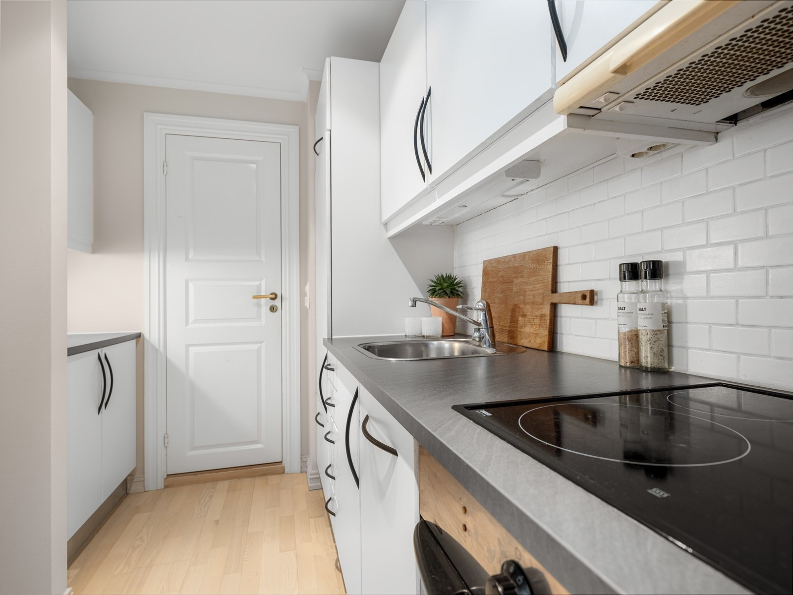 Stilrent kjøkken med hvit kjøkkeninnredning og glatte fronter. Galleribilde