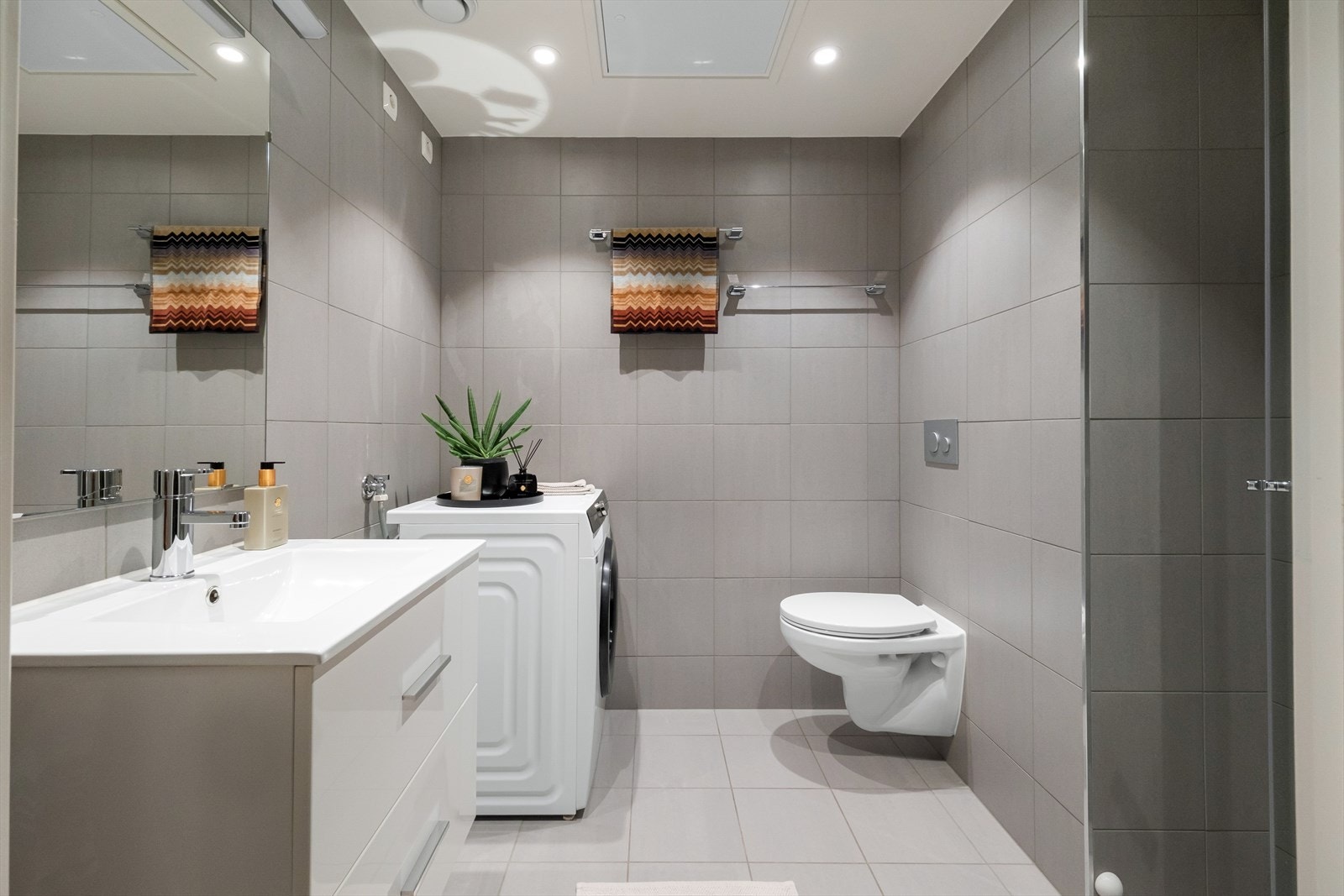 Det er et stort bad med delikate fliser på vegger og gulv. Galleribilde