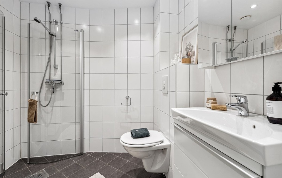 Delikat flislagt bad med varmekabler i gulv og downlights i himling. Badet ble pusset opp i 2013 i regi av sameiet. Innredningen består av veggmonterte dusjvegger, veggmontert klosett, servantskap med skuffer og speilskap med belysning. Galleribilde