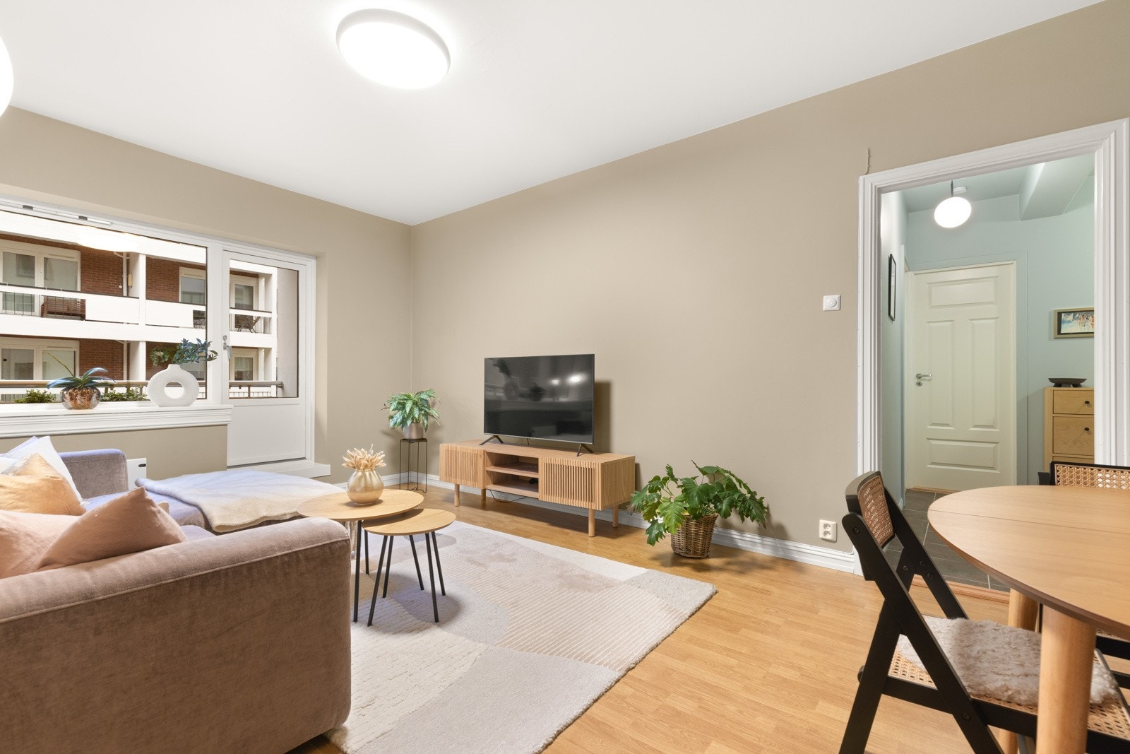 Lyst og sosialt oppholdsrom med god plass til spisebord, sofaseksjon og tv-møblement. Veggene er helsparklet og nymalte i 2023 i en varm sandfarget tone. Galleribilde