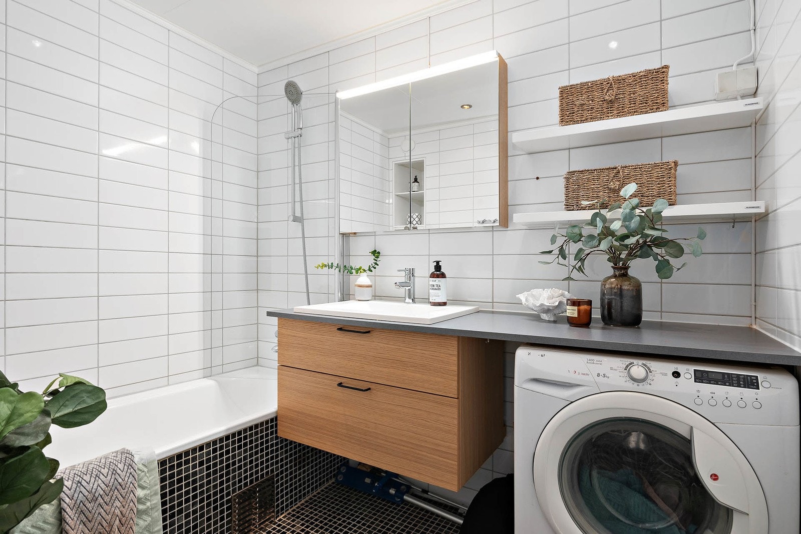 Lekkert bad med varmekabler, downlights, badekar og opplegg for vaskemaskin Galleribilde