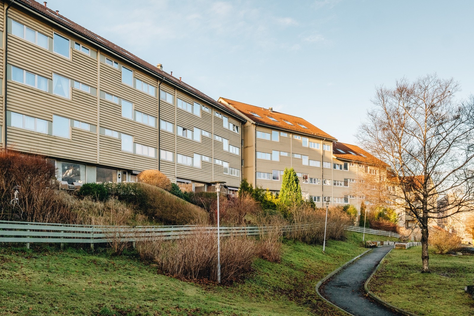 Leiligheten ligger i første etasje, men likevel meget privat og skjermet. Legg merke til inngjerdingen av hagen i front av leiligheten. Galleribilde