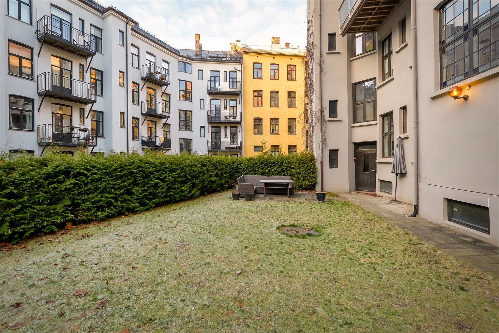 Hyggelig bakgård med sittegrupper og fine grøntareal Galleribilde