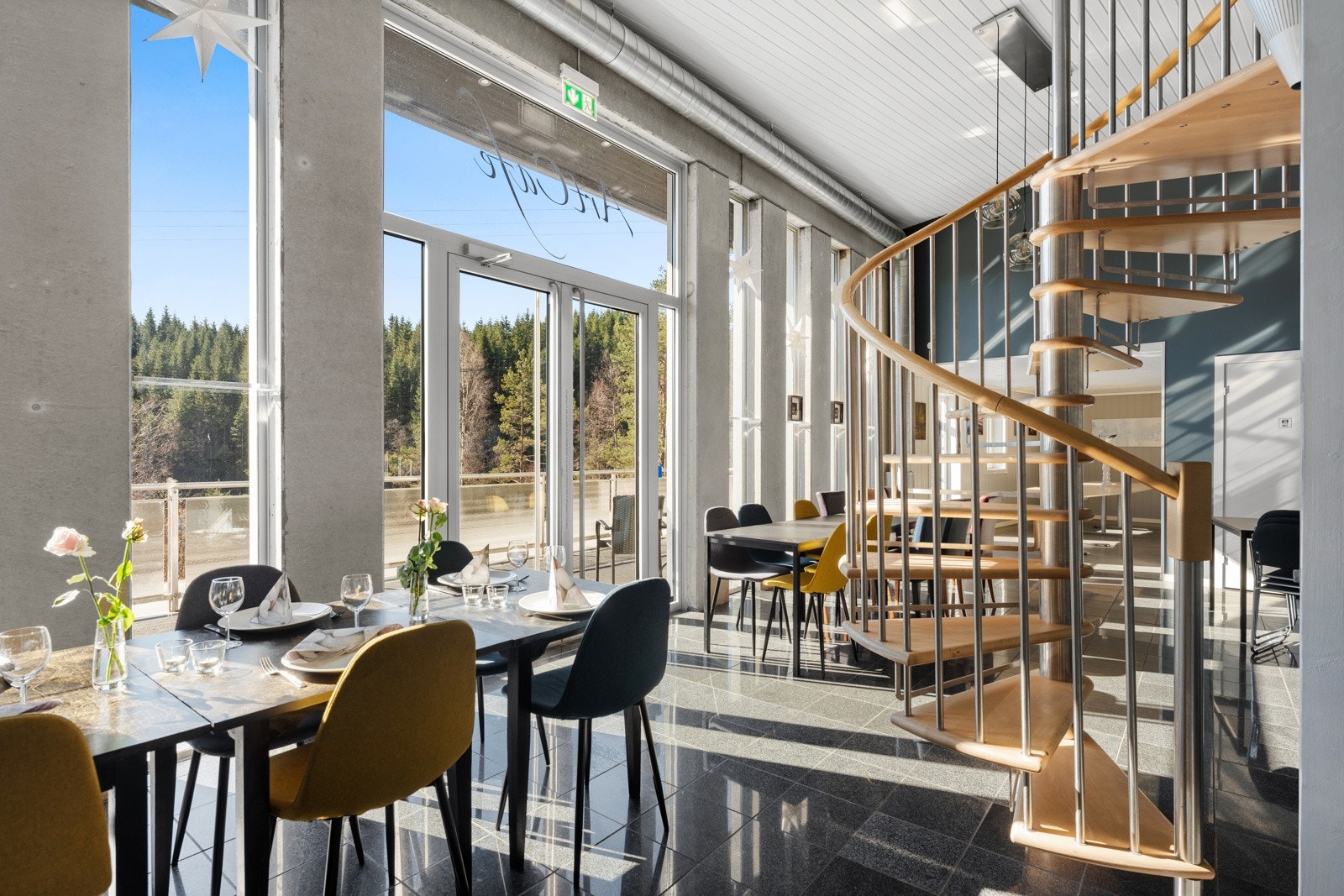 Stilig lokale med fliselagt gulv og betong / glass elementer på veggene. Deler av lokalet har åpent opp i 2 etasjer med vindeltrapp til tilhørende galleri i 2. etasje. Galleribilde