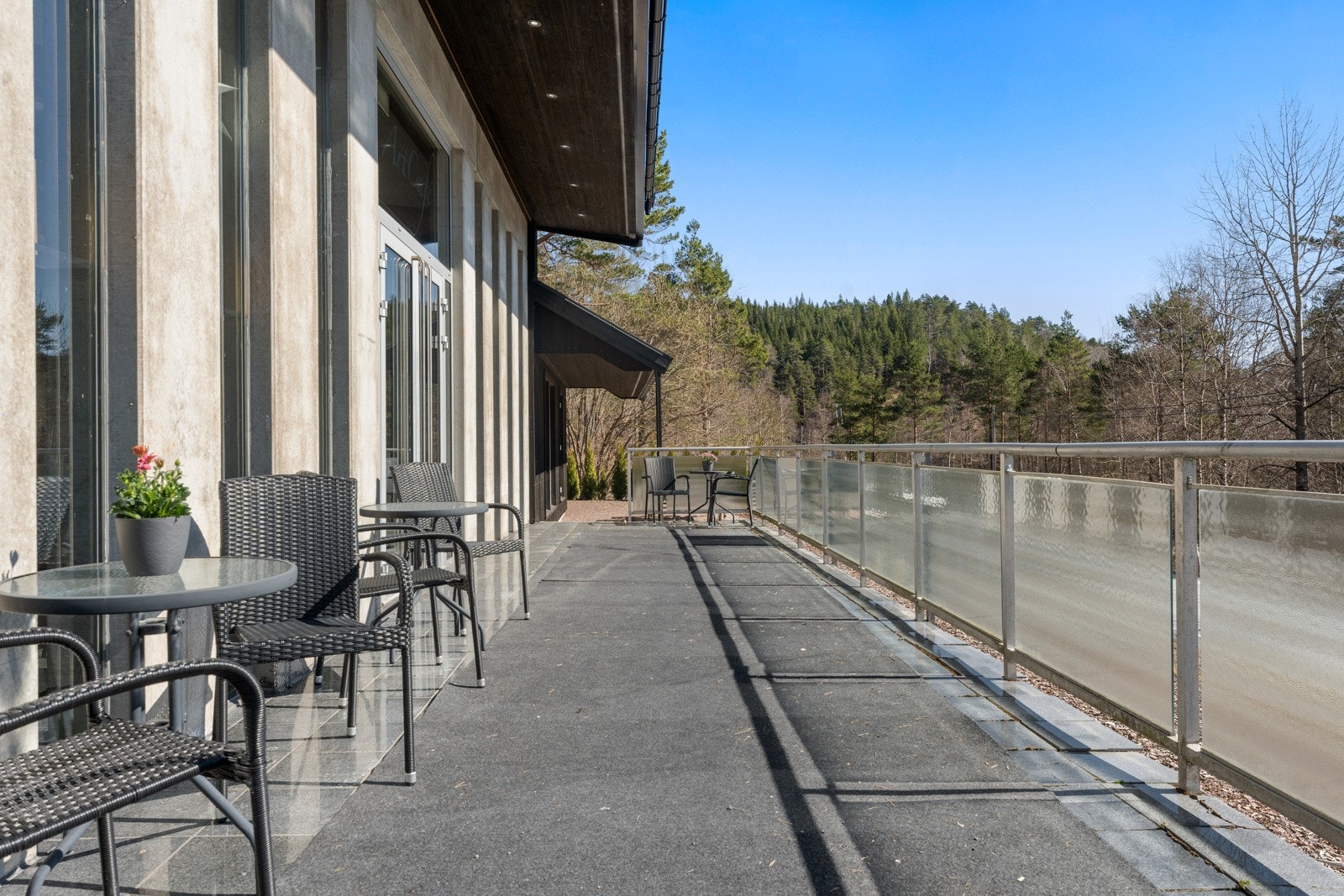 Stor fliselagt terrasse utenfor selskapslokalet. Galleribilde