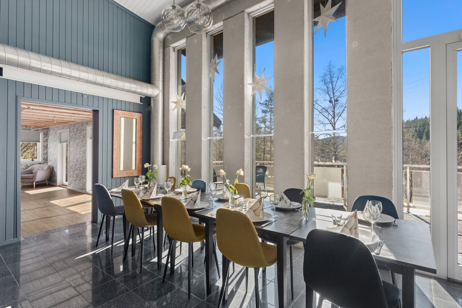 Store vindusflater og takhøyde over 2 etasjer åpner for mye lys og en flott nærhet til naturen. Videre overgang til lounge lokalet. Galleribilde