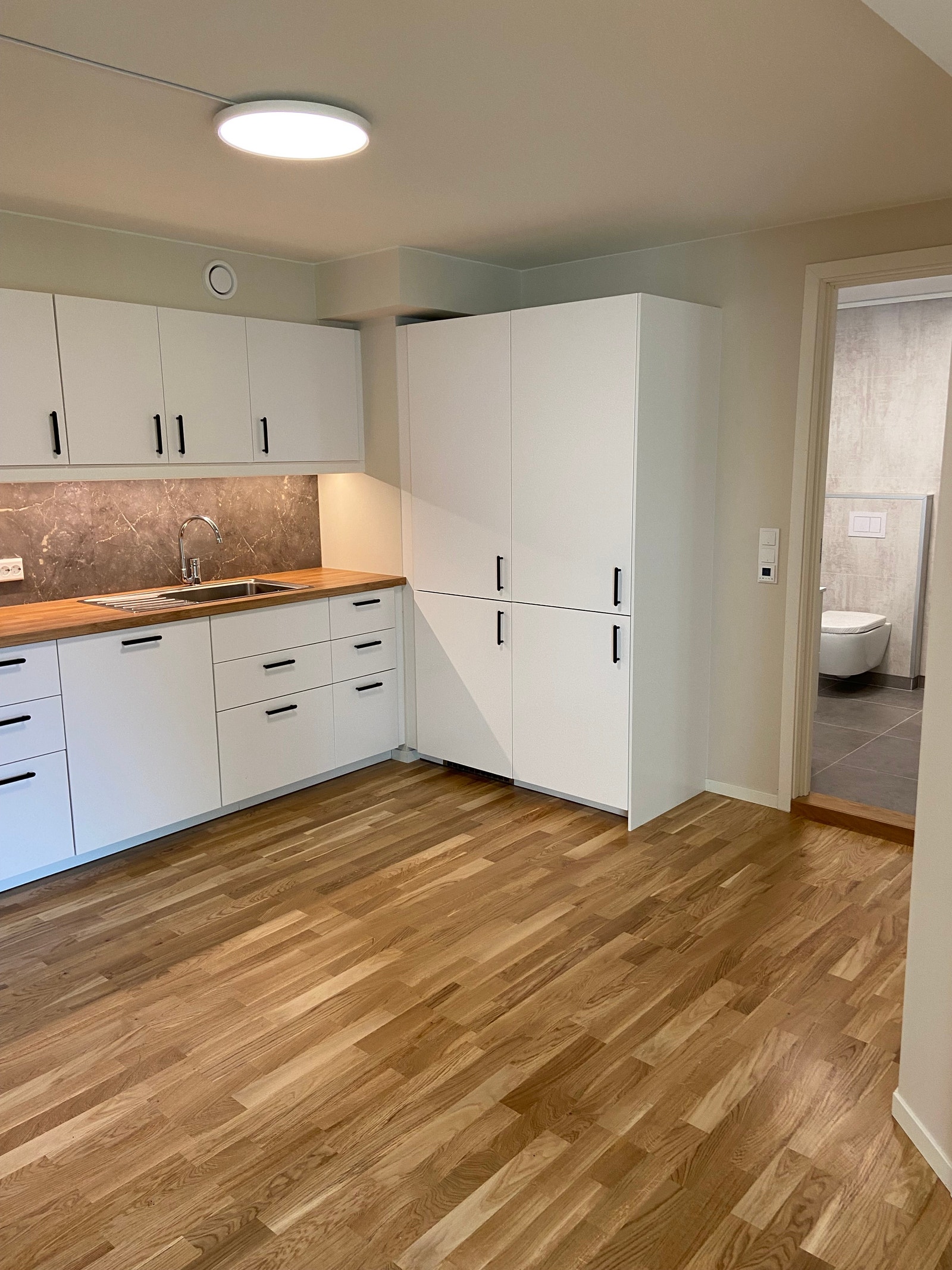 Kjøkken med mye oppbevaring og plass til spiseplass Galleribilde