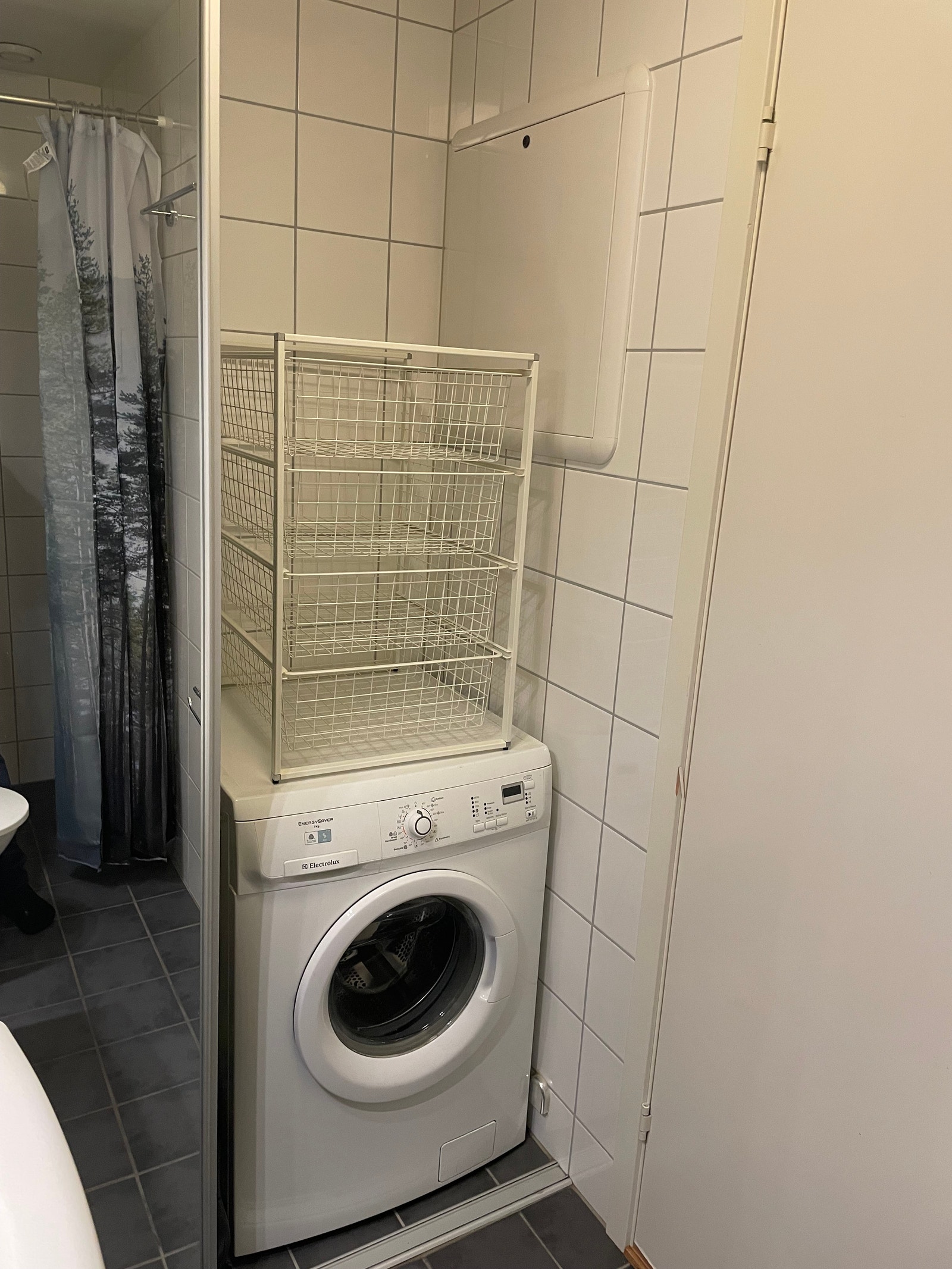 Vaskemaskin og ekstra hyller bak speilskap Galleribilde