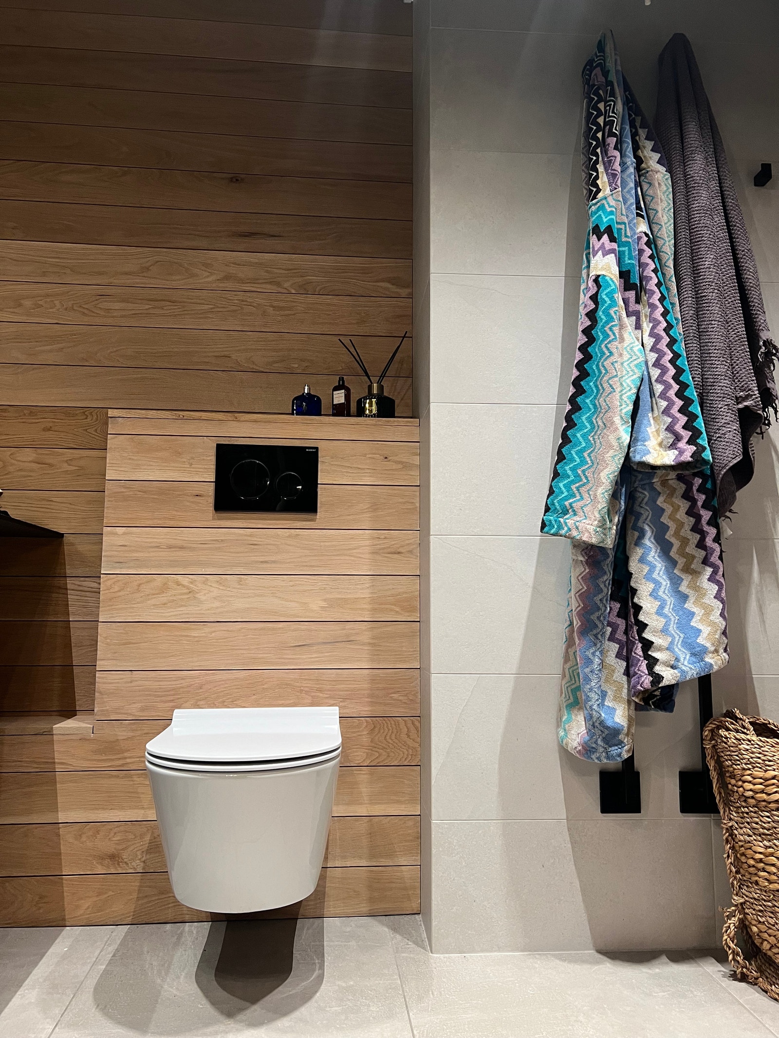 Badet har en kombinasjon av fliser og eikepanel Galleribilde