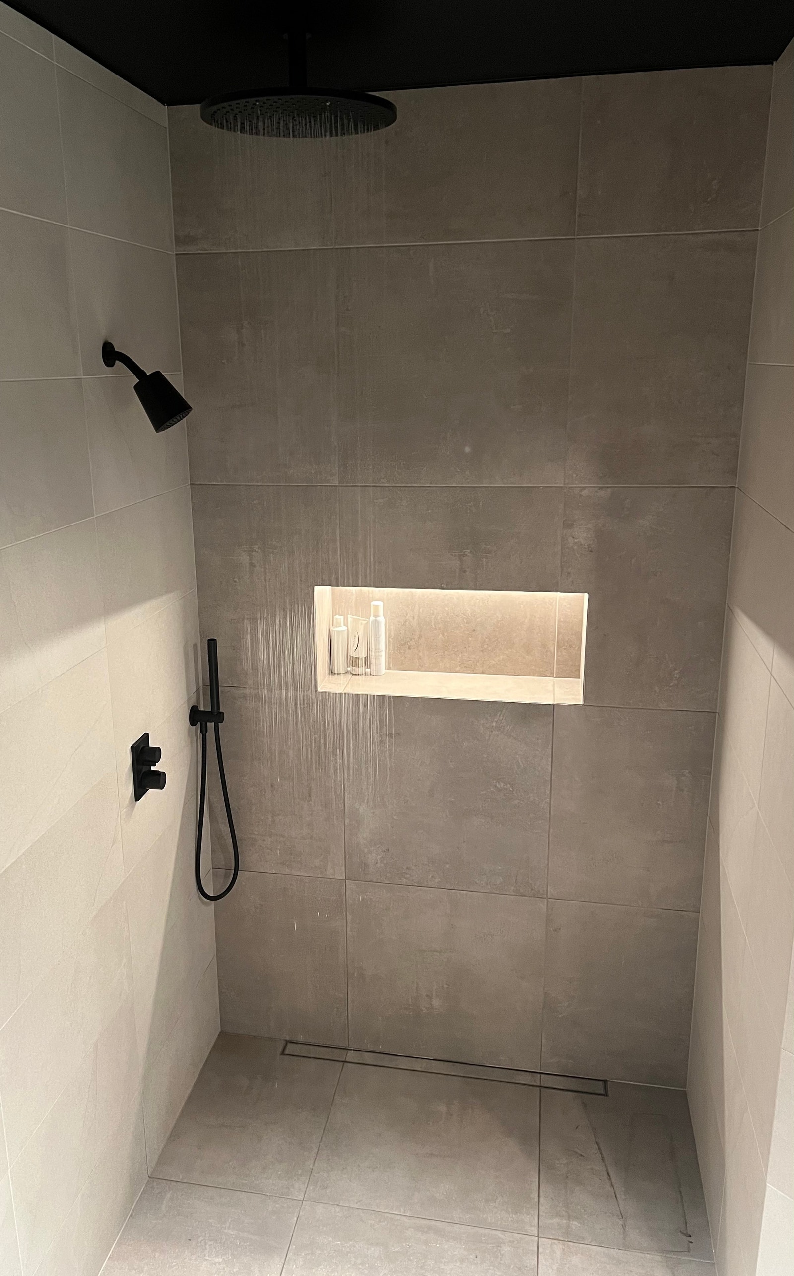 Badet har dusj med rainfall og dusjhode - armatur fra DornBracht og dusjnisje med ledlys Galleribilde