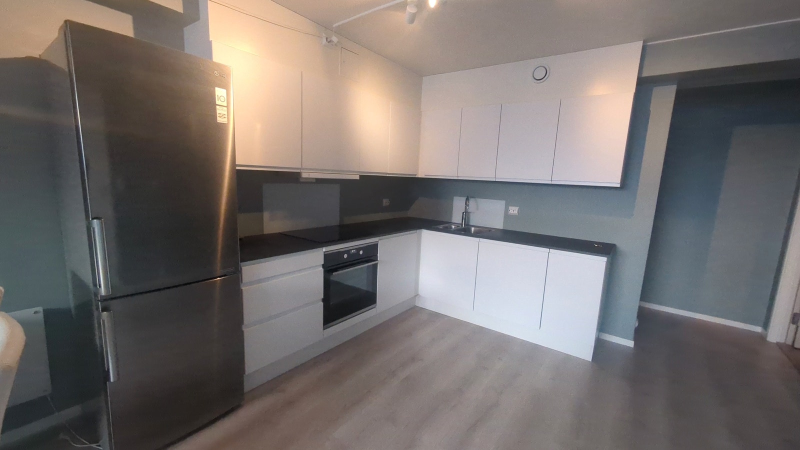 Romslig kjøkken med oppvaskmaskin,induksjon platetopp og stekeovn. Galleribilde