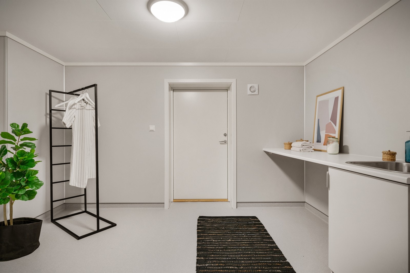 Underetasjen har stort vaskerom med god plass til garderobeløsning. Det er også egen inngangsdør, slik at dette kan brukes som en grovinngang. Galleribilde