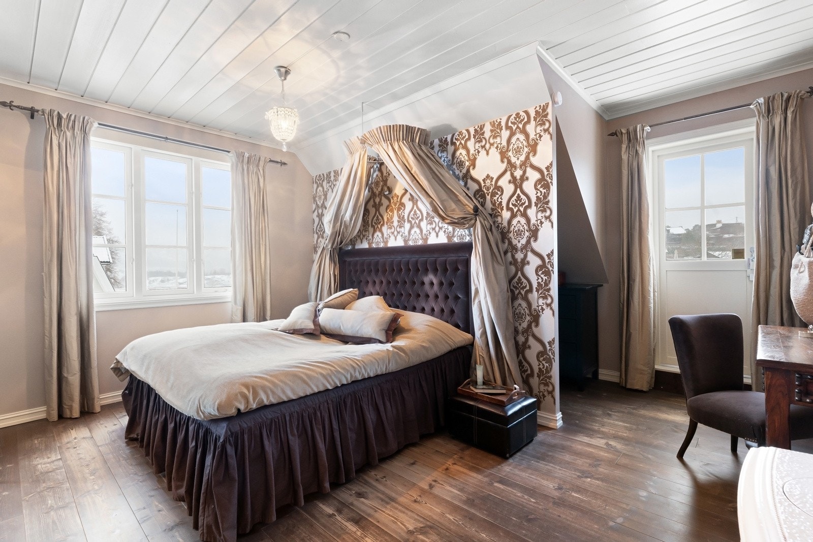 Hovedsoverommet er et av høydepunktene i huset, et stort og innbydende rom med vedovn, tregulv, eget bad og pipe kledd i store, lekre fliser. Galleribilde