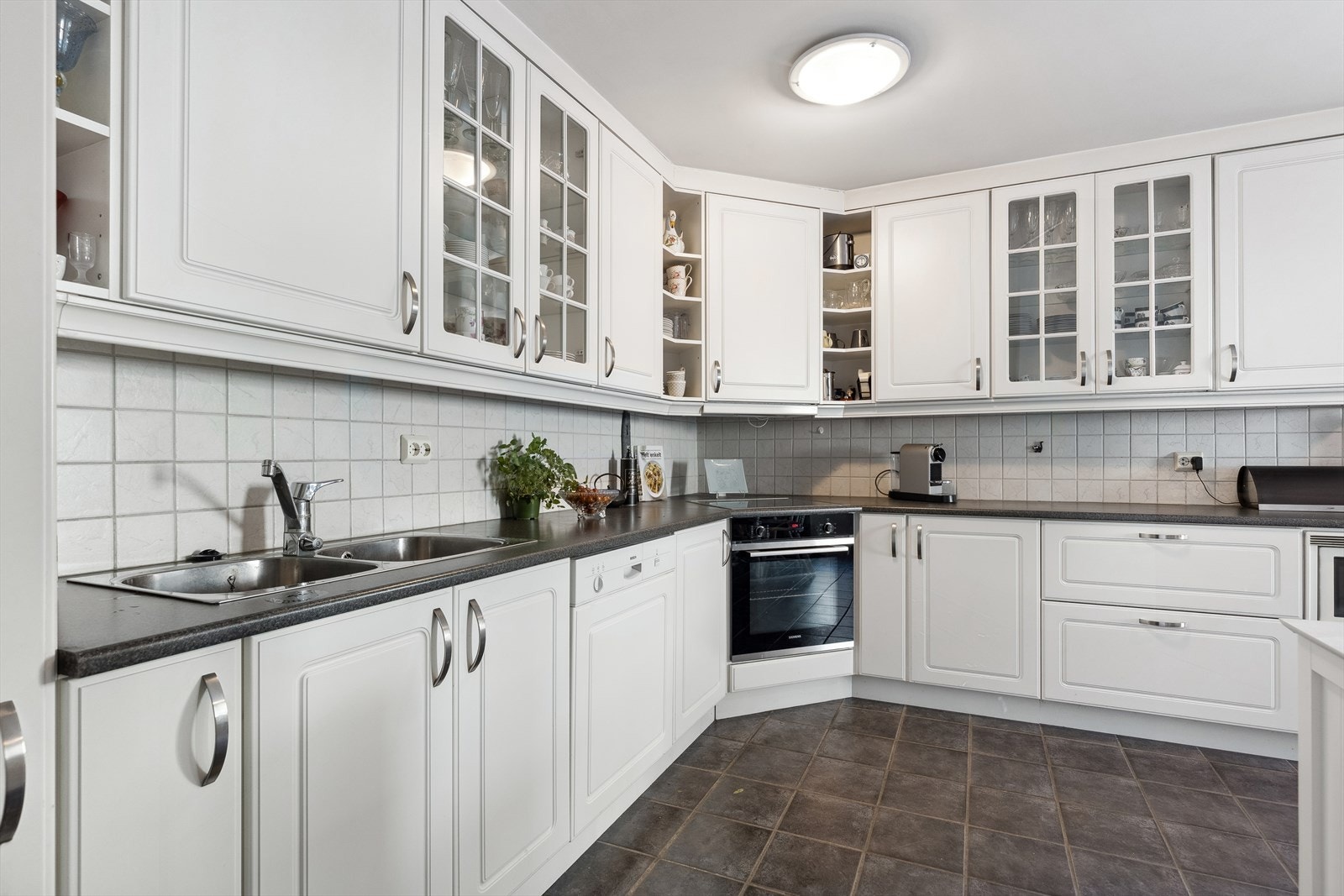 Stort kjøkken med flislagt gulv med gulvvarme. Galleribilde