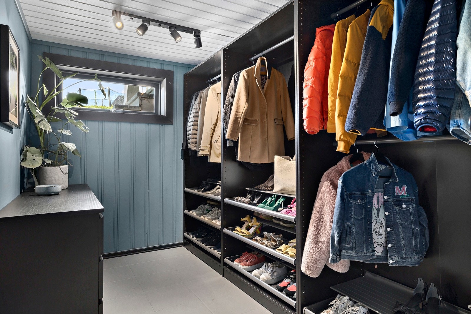 Hallen har et matchende garderoberom, og langs den ene veggen er det et stort skap med skohyller og stenger for oppheng. Galleribilde