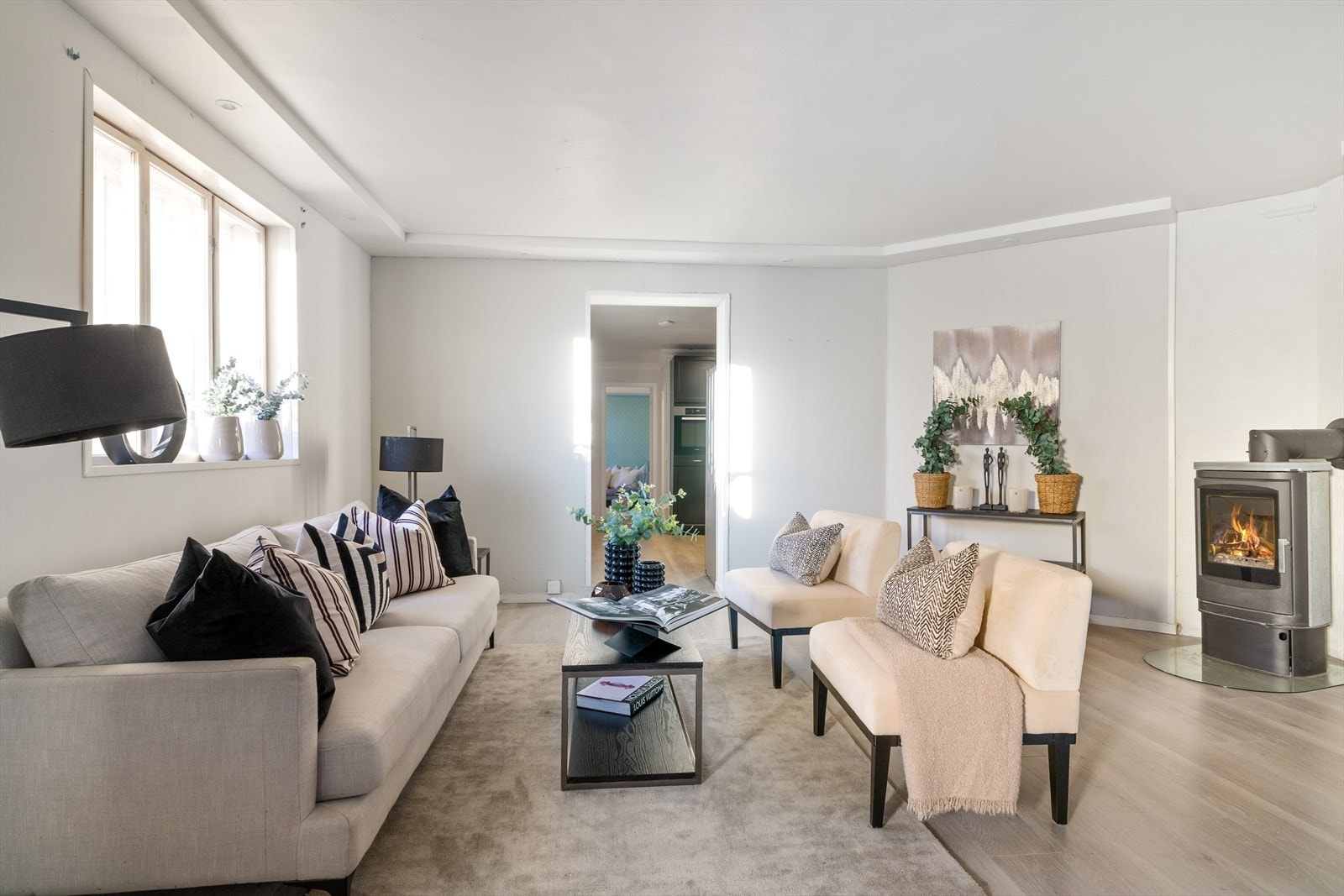 Leiligheten har en stor og lys stue med peis. Galleribilde