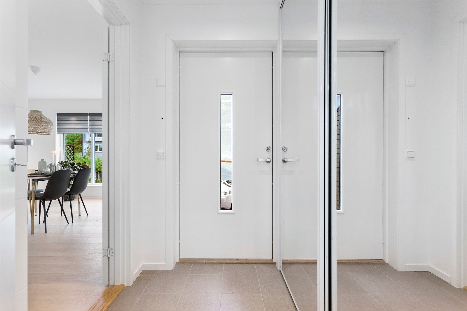 Entré med fliser på gulv og en praktisk skyvedørsgarderobe for oppbevaring av sko og yttertøy. Galleribilde