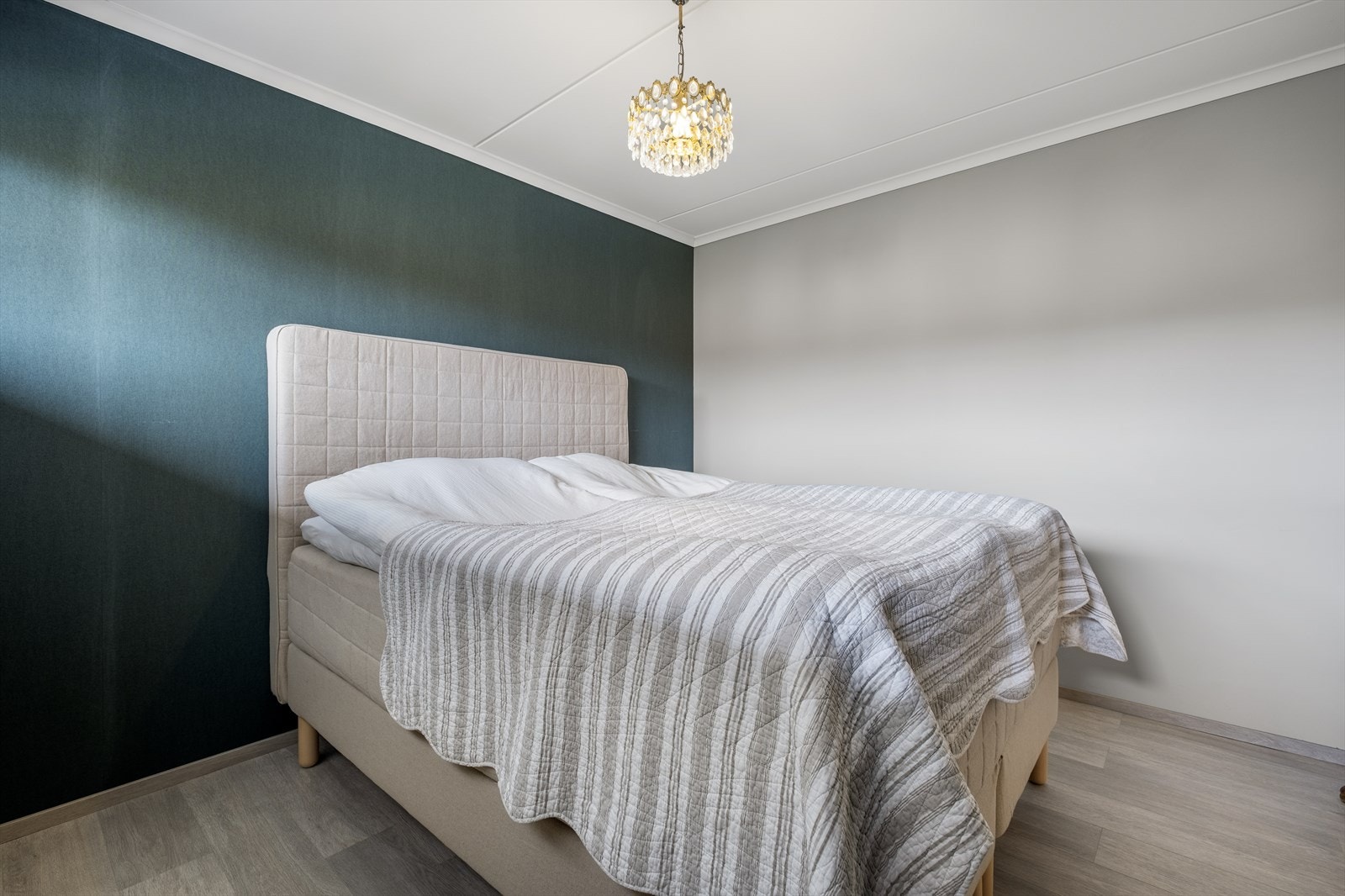 Soverommet har en grønn, trendy kontrastvegg som skaper en god stemning på soverommet. Galleribilde