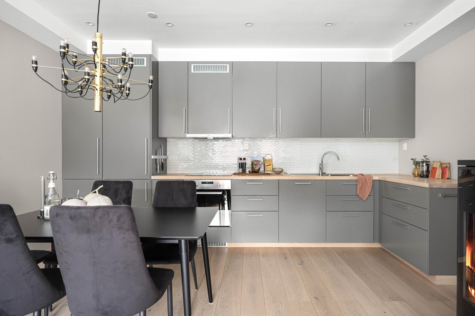 Videre er kjøkkenet innredet med integrerte hvitevarer, herav kjøleskap med frysedel, komfyr, oppvaskmaskin og nedfelt platetopp Galleribilde