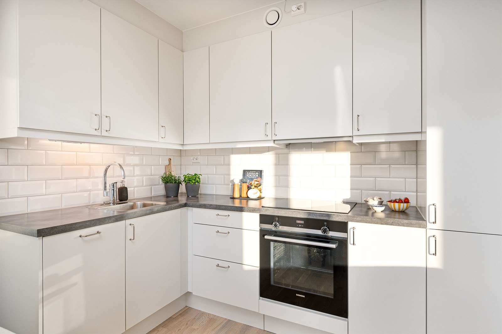 Flott, stilrent hjørnekjøkken med god skap- og benkeplass. Hvitevarene medfølger handelen. Galleribilde