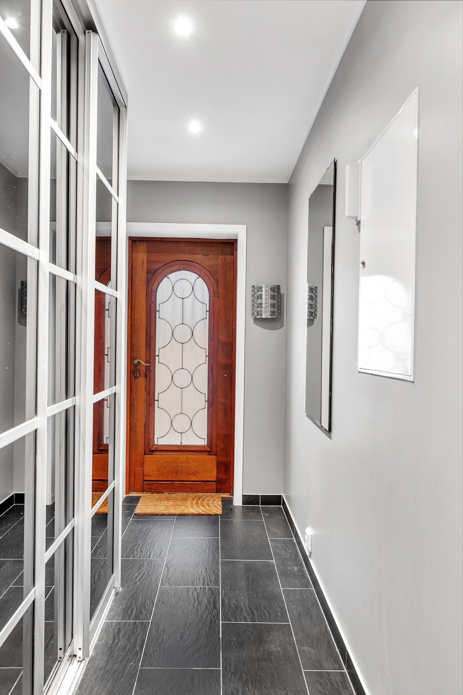 Velkommen inn! Det første som møter deg er denne flislagte gangen hvor det er montert praktisk skyvedørsgarderobe Galleribilde