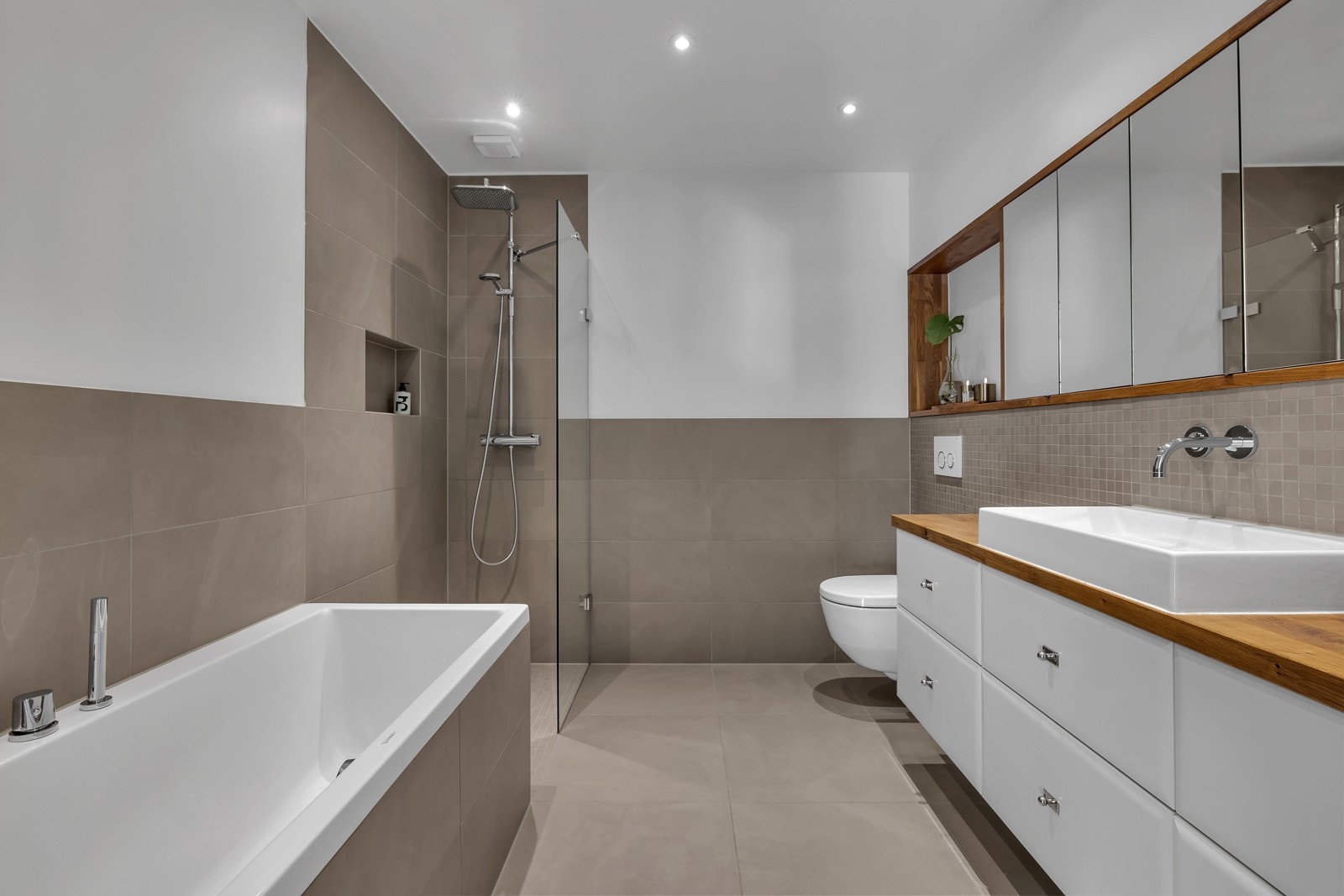 Badet er innbydende og pent med både badekar, dusj, fin innredning og innfelt belysning i tak Galleribilde